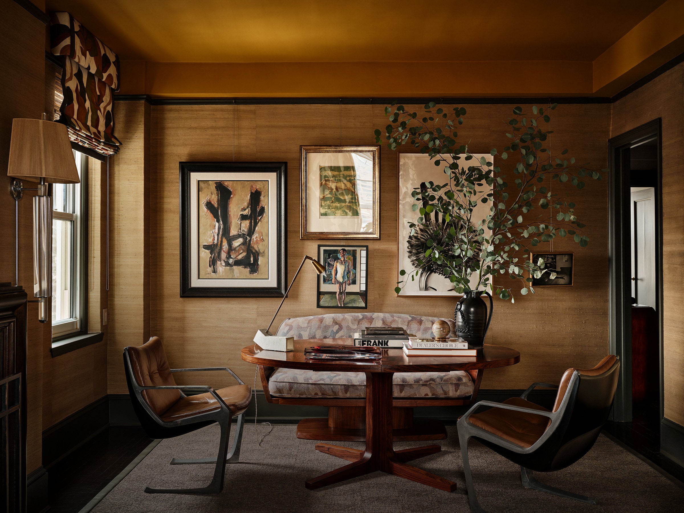 Dining room with wooden table, chairs, and wall art in a warm-toned room.